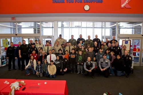 The whole group of officers, deputies, chiefs and happy kids.