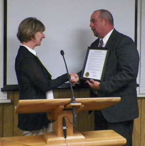 Judge Canfield's wife, Dori, receives proclamation from Bishop Mayor Jim Ellis.