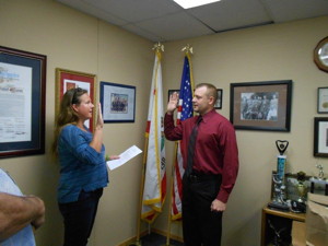 Town Clerk Jamie Gray swears in Officer Grant Zemel.