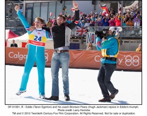  Eddie (Taron Egerton) and his coach Bronson Peary (Hugh Jackman) rejoice in Eddie’s triumph.