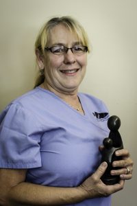 Rhonda Aihara, Northern Inyo Healthcare District’s 2016 DAISY Award winner, holds the handmade DAISY Award sculpture, “A Healer’s Touch.” Photo by Barbara Laughon/Northern Inyo Hospital 