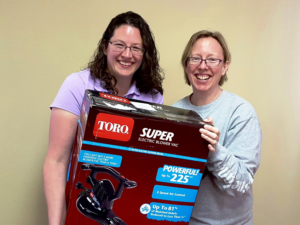 Pastor Erin McPhee on left Ann Strohm right Toro Electric Blower and Vacuum donated by True Value Hardware